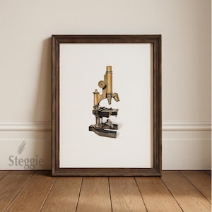 May include: Framed print of a vintage microscope. The microscope is rendered in shades of gold and bronze, with intricate details. The frame is dark brown, and the background is white. The print is displayed on a wooden floor.