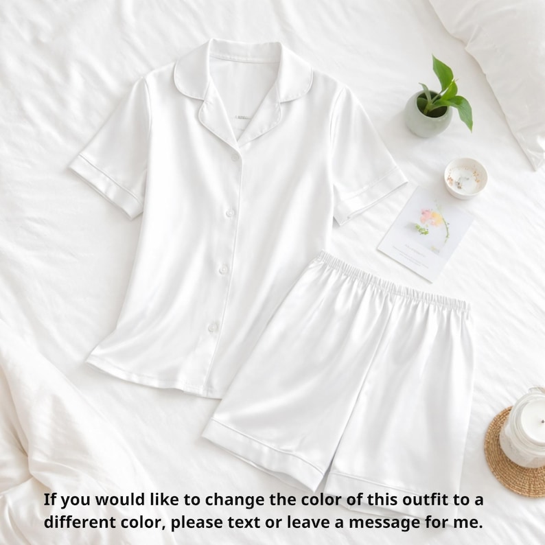 Puede incluir: Conjunto de pijama blanco con una camisa abotonada de manga corta y pantalones cortos a juego. El conjunto est&aacute; hecho de una tela suave y sedosa. El texto de la imagen dice: "Si desea cambiar el color de este atuendo..."