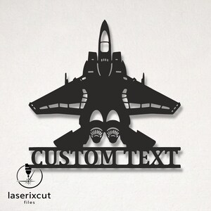 May include: A black metal wall art piece shaped like a fighter jet silhouette, featuring two jet engines at the base and a horizontal bar below with the words CUSTOM TEXT cut out in a bold, capitalized serif font, creating a decorative display.