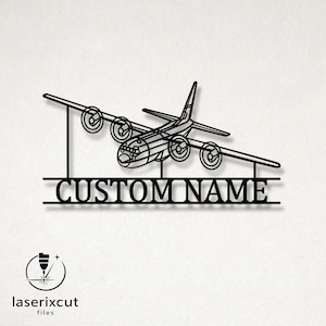 Puede incluir: Una pieza de arte mural de metal negro con la silueta de líneas de un avión de carga de cuatro motores sobre dos líneas horizontales que enmarcan el texto CUSTOM NAME en una fuente sans-serif, creando un letrero personalizado.