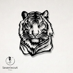 May include: A black laser-cut metal tiger head. The artwork shows intricate details of the tiger's fur and face. The image includes the text "laserixcut files" in the bottom left corner. A decorative piece for home or office.