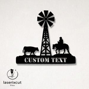 Może przedstawiać: Czarna metalowa grafika ścienna przedstawiająca wiatrak, krowę i kowboja na koniu. Słowa "CUSTOM TEXT" są wycięte pod postaciami. Logo Laserixcut files znajduje się w lewym dolnym rogu.