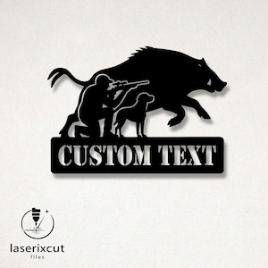 Pode incluir: Arte de parede em metal preto com um caçador apontando uma espingarda, um cão e um javali em carga. As palavras "CUSTOM TEXT" são exibidas em uma placa retangular. O logotipo "laserixcut files" está no canto inferior esquerdo.
