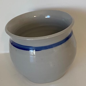 May include: A set of three ceramic mugs with a speckled, matte finish. The mugs are in shades of cream, light brown, and dark brown. Each mug has a simple, minimalist design, perfect for coffee or tea.