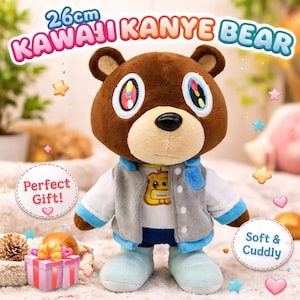 Puede incluir: Un oso de peluche marrón, de 26 cm de altura, con ojos grandes y coloridos y una nariz negra. El oso lleva una chaqueta gris, una camisa blanca y zapatos azules. El texto en la imagen dice "KAWAII KANYE BEAR" y "Soft & Cuddly".