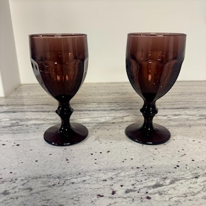 May include: A set of three ceramic mugs with a speckled, matte finish. Each mug features a different color: light blue, cream, and gray. The mugs have a simple, modern design with a rounded shape and a comfortable handle.