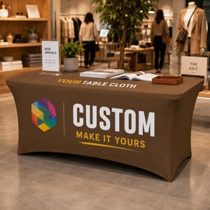 Op de afbeelding: Een bruin, rekbaar tafelkleed met een kleurrijk geometrisch zeshoekig logo aan de linkerkant en witte tekst die CUSTOM MAKE IT YOURS leest. De bovenkant van het kleed toont de tekst YOUR TABLE CLOTH in het wit, gecentreerd op het bruine oppervlak.