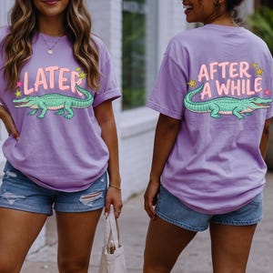 Puede incluir: Dos camisetas lavanda con un diseño de cocodrilo de dibujos animados. Una camiseta dice "LATER" y la otra "AFTER A WHILE". El cocodrilo es verde con detalles en rosa. Las camisetas se combinan con pantalones cortos de mezclilla.