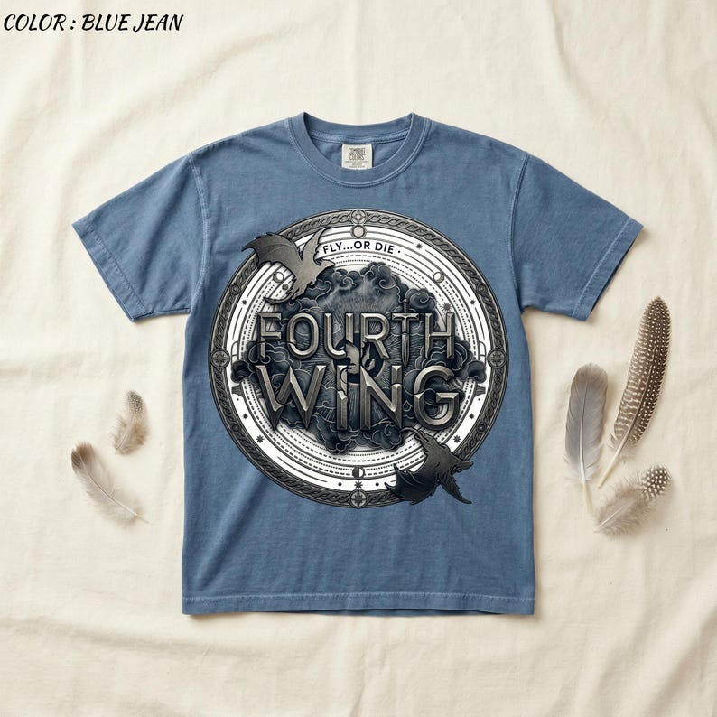 May include: Blue jean colored t-shirt with a circular graphic featuring the text "FOURTH WING" in a stylized font. The graphic includes two bat-like creatures and the words "FLY...OR DIE".