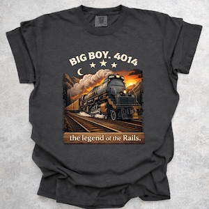 May include: Dark gray t-shirt featuring a detailed illustration of a steam train on tracks, with the text "BIG BOY. 4014" and "the legend of the Rails." The design includes a sunset and mountain backdrop.