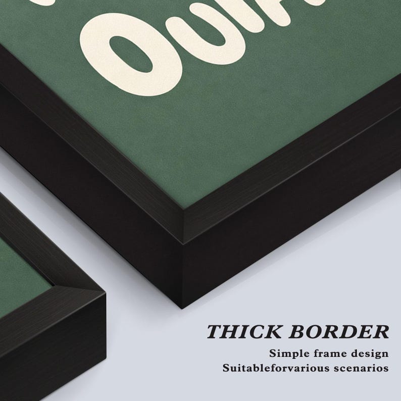 May include: Close-up of framed artwork with a thick black border. The artwork has a green background with white text. The text is partially visible, with the word "Our" in large letters. The bottom right corner of the frame is visible.