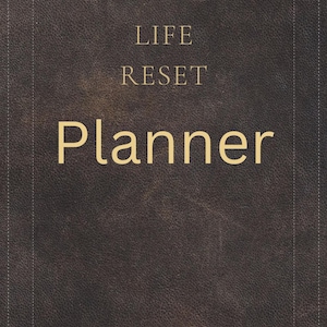 Może przedstawiać: Brązowy planer o fakturze skóry z napisem "LIFE RESET Planner" złotymi literami. Planer ma szytą obwódkę i prosty, elegancki design. Okładka jest w jednolitym, ciemnobrązowym kolorze.