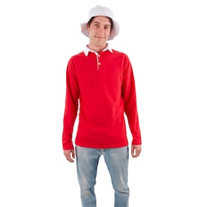 May include: A man wearing a red long-sleeved polo shirt with a white collar and a white bucket hat. He is wearing blue jeans and white sneakers.