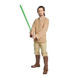 May include: A person wearing a brown robe and brown boots holds a green lightsaber in their right hand.