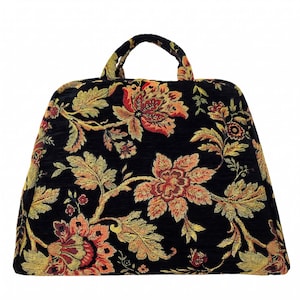 May include: A structured handbag featuring a black fabric base with a woven floral tapestry pattern in shades of red, orange, gold, and green. The bag has a trapezoidal shape with a single top handle and a textured, multi-colored botanical design.