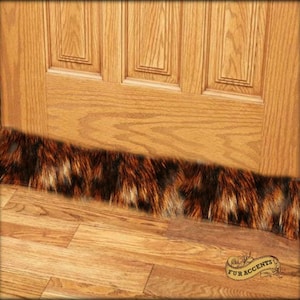 May include: A brown and black faux fur door draft stopper. The draft stopper is placed at the bottom of a wooden door.