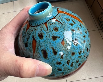 A unique peacock blue vase, a ceramic vase with a mottled pattern.