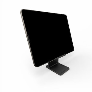 May include: A black tablet is mounted on a black stand, angled slightly upward. The stand has a square base and a vertical support. The tablet's screen is black, and the edges are silver.