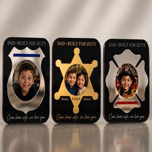 May include: Three black photo frames with cutouts shaped like a police badge, sheriff's star, and firefighter's emblem. Each frame has a photo of a child and the text "DAD • BUILT FOR DUTY" and "Come home safe, we love you."
