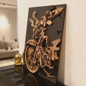 May include: A layered wooden artwork of a motorcycle. The piece features a dark grey background with a detailed, light-coloured wooden motorcycle design. The motorcycle's wheels, engine, and handlebars are intricately carved, creating a 3D effect. The artwork is mounted on a wall.