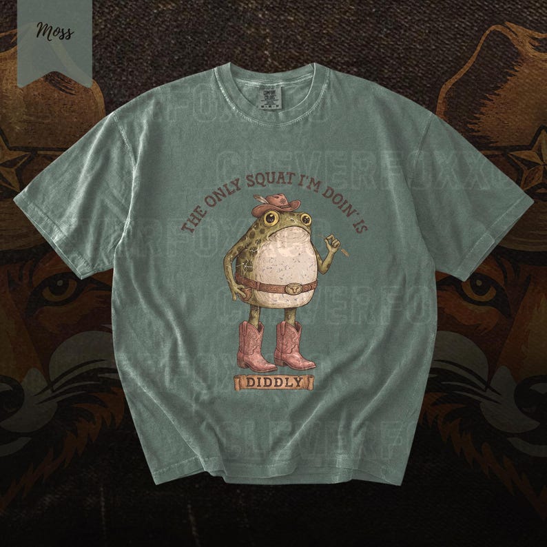 A t-shirt with a cartoon frog wearing cowboy boots and a hat, along with the text "The only squat I'm done is Diddly" printed on it.