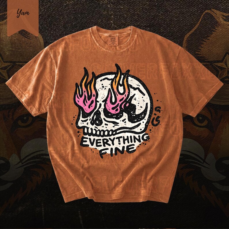 Puede incluir: Camiseta naranja con un dise&ntilde;o de calavera blanca con llamas rosas y amarillas. El texto "EVERYTHING FINE" est&aacute; impreso debajo. La camiseta tiene un aspecto vintage.