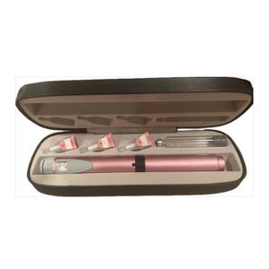 May include: Open black case containing a pink medical pen, three needles with pink and white labels, and a clear glass vial. The case has a light tan interior and is open, revealing the contents.
