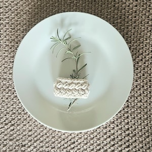 Könnte beinhalten: Ein Set aus drei Keramikbechern mit gesprenkelter, matter Oberfläche. Die Becher sind in den Farbtönen Creme, Hellgrau und Dunkelgrau gehalten. Jeder Becher hat ein schlichtes, minimalistisches Design und einen abgerundeten Henkel.