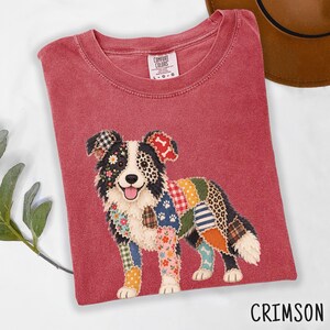 May include: A crimson red crew neck t-shirt with a Comfort Colors label at the collar. The center features a graphic of a dog composed of various colorful patchwork patterns, including floral, plaid, polka dot, and animal print designs.