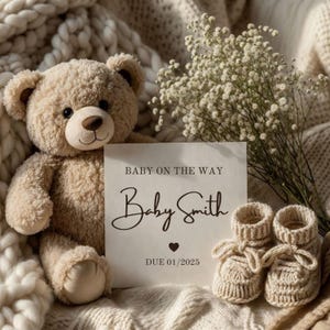 May include: A beige teddy bear, a card with the text "BABY ON THE WAY" and "Baby Smith", and a pair of knitted baby booties are arranged on a soft, textured blanket. A bouquet of white flowers adds a delicate touch. The due date is January 2025.