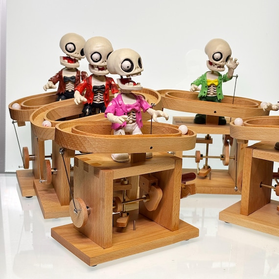 A hand-cranked wooden zombie automata in folk-art style — each piece is one-of-a-kind outsider art that shuffles and lurches with mechanical charm.