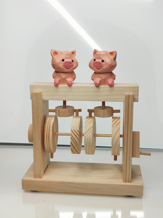 A handcrafted wooden pig automata where turning a crank brings the pig to life — mechanical kinetic art that is genuinely rare and delightfully whimsical.