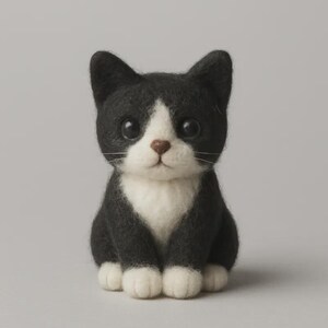 May include: A needle felted cat figurine featuring black and white fur. The cat has a black head and back with a white chest, muzzle, and paws. It has large, dark, glossy eyes, a small brown nose, and thin white whiskers on a neutral background.