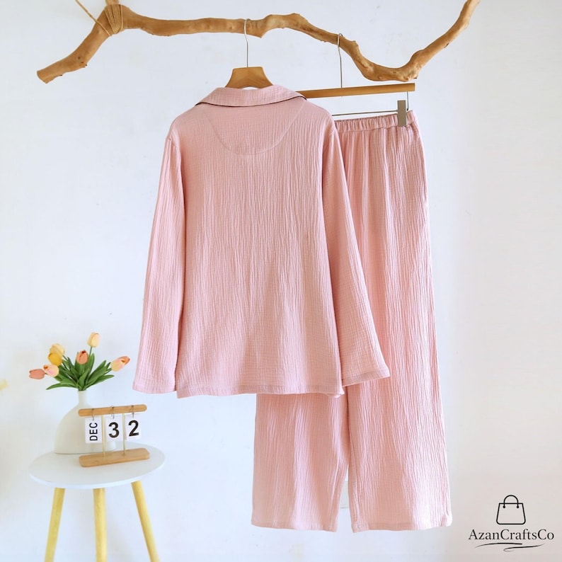 Może przedstawiać: Biały ceramiczny kubek z czarnym uchwytem i napisem "But First, Coffee" czarną, odręczną czcionką. Kubek stoi na białej powierzchni.