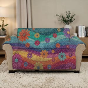 May include: A sofa cover with a bright floral pattern. The cover displays a spectrum of colours, including blue, green, orange, yellow, and purple. Large embroidered flowers are spread across the cover, creating a cheerful appearance. The cover is draped over a beige sofa.
