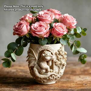 May include: A cream-colored cylindrical silicone mold featuring a relief sculpture of a small dragon with wings tucked inside an arched stone doorway, surrounded by floral carvings. Text reads: Please Note: This is a mold only, finished product not included.
