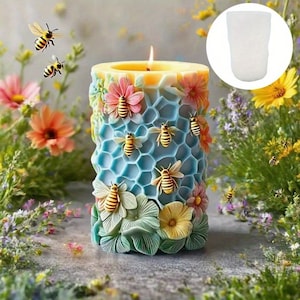 May include: A decorative candle with a bee and honeycomb design. The candle features a light blue honeycomb pattern, adorned with bees and colorful flowers. The candle is lit, and the background includes flowers and greenery.