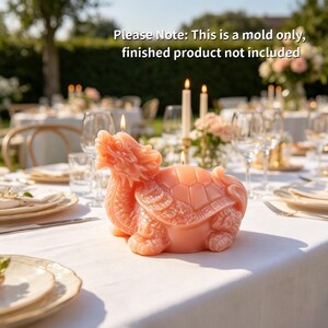 May include: A peach-colored silicone mold shaped like a dragon turtle with intricate scales and a shell. The text "Please Note: This is a mold only, finished product not included" is visible at the top of the image. The mold is on a white table.