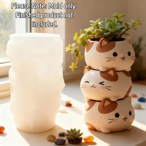 May include: A translucent white silicone mold for a planter, accompanied by a stack of three ceramic cat-shaped planters with brown and white markings. The text "Please Note: Mold only. Finished product not included." is visible in the upper left corner.
