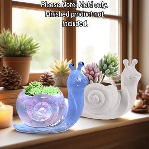 May include: Two snail-shaped silicone molds for planters. One mold is iridescent blue, and the other is solid white. The text 'Please Note: Mold only. Finished product not included.' is visible at the top of the image.