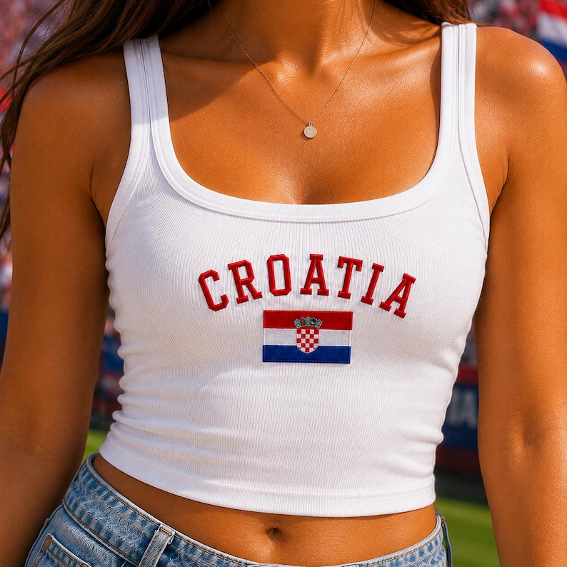 May include: A white ribbed vest top featuring the word CROATIA embroidered in red capital letters across the chest. Below the text is a small, rectangular embroidered patch of the Croatian flag, displaying horizontal red, white, and blue stripes with the national coat of arms in the centre.