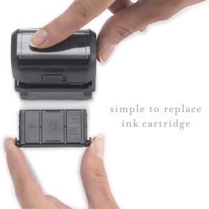 Może przedstawiać: Czarny wkład atramentowy jest wymieniany w czarnym stemplu samousuwającym. Tekst "simple to replace ink cartridge" jest widoczny pod stemplem.