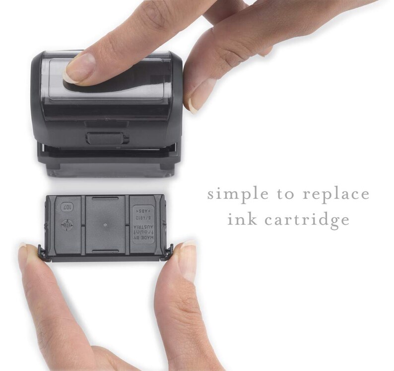 Może przedstawiać: Czarny wkład atramentowy jest wymieniany w czarnym stemplu samousuwającym. Tekst "simple to replace ink cartridge" jest widoczny pod stemplem.