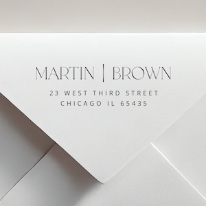 May include: White envelope with the return address "MARTIN | BROWN" printed in black. The address includes "23 WEST THIRD STREET, CHICAGO IL 65435". The design is minimalist and modern.