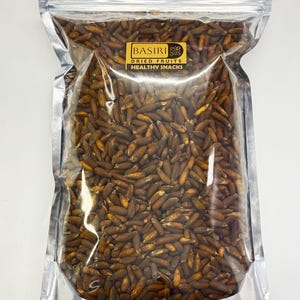 Puede incluir: Una bolsa transparente y resellable llena de frutos secos marrones y oblongos. La bolsa tiene una parte superior de papel de aluminio plateado y una etiqueta dorada con el texto "BASIRI DRIED FRUITS HEALTHY SNACKS". Las frutas están densamente empaquetadas.