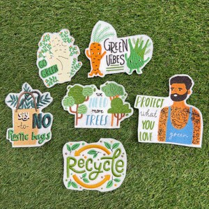Puede incluir: Seis parches bordados con temas medioambientales. Los diseños incluyen una mano con 'GO GREEN', una zanahoria y planta con 'GREEN VIBES', una bolsa con 'say NO to plastic bags', árboles con 'we NEED more TREES', una persona con 'PROTECT what YOU LOVE' y un símbolo de reciclaje.