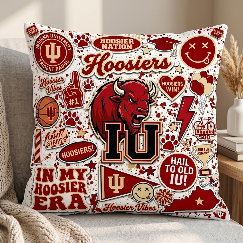 Puede incluir: Coj&iacute;n cuadrado blanco con gr&aacute;ficos rojos y negros. Incluye textos como "Hoosiers" e "IU", junto con un bisonte rojo, huellas de patas y una pelota de baloncesto.