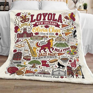Puede incluir: Manta crema de la Universidad Loyola de Nueva Orleans con un dise&ntilde;o gr&aacute;fico detallado. Presenta el texto "Loyola New Orleans" y "Olivia Chen Class of 2026", junto con ilustraciones de monumentos, un lobo e instrumentos musicales.