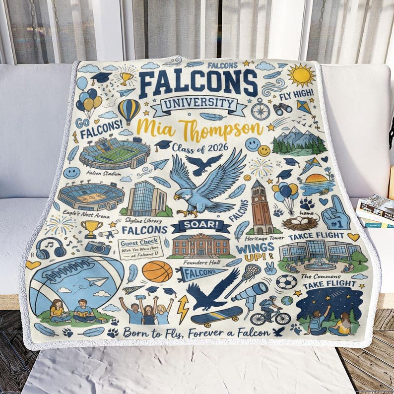 Puede incluir: Una manta personalizada con un dise&ntilde;o azul y dorado, con el texto "FALCONS UNIVERSITY" y el nombre "Mia Thompson, Clase de 2026." La manta incluye ilustraciones de un halc&oacute;n, un estadio y otros iconos universitarios.
