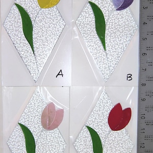 May include: Four diamond-shaped mosaic tiles, each featuring a tulip design. The tulips are in yellow, purple, pink, and red, with green leaves. The background is a textured white. Letters A, B, C, and D are visible.